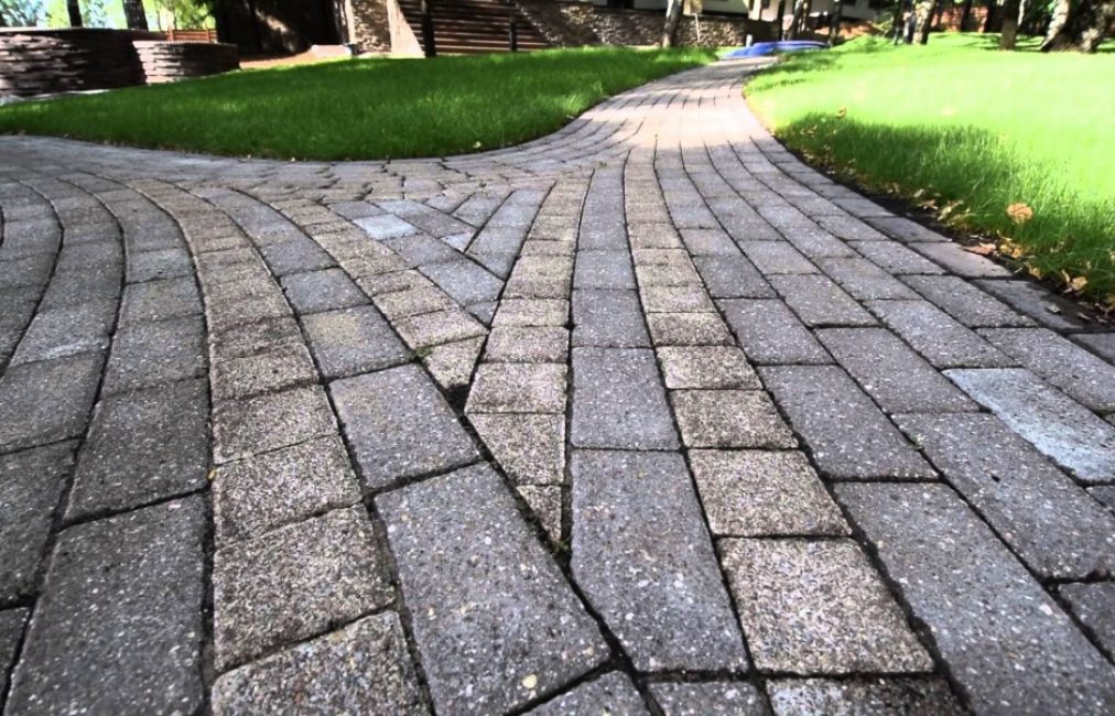 Las losas de pavimentación grises combinadas con césped se ven atractivas
