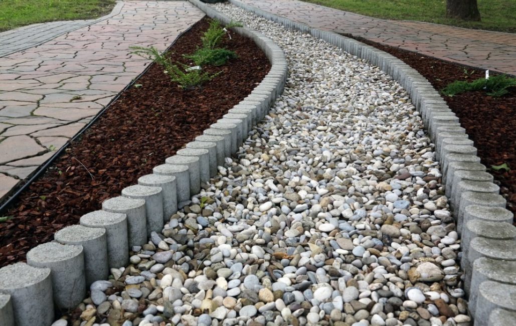 Camino combinado de losa de piedra, materia orgánica y ripio con bordillo de cemento