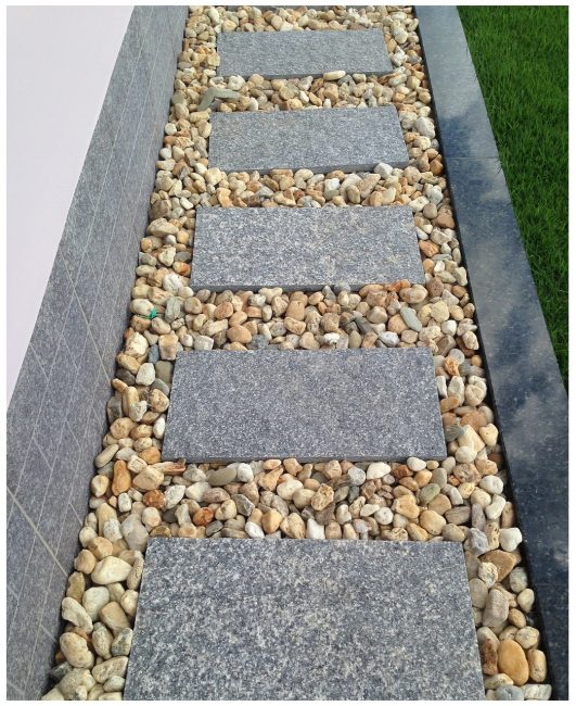 Beton levhalar ve çakıllardan yapılmış yürüyüş yolu
