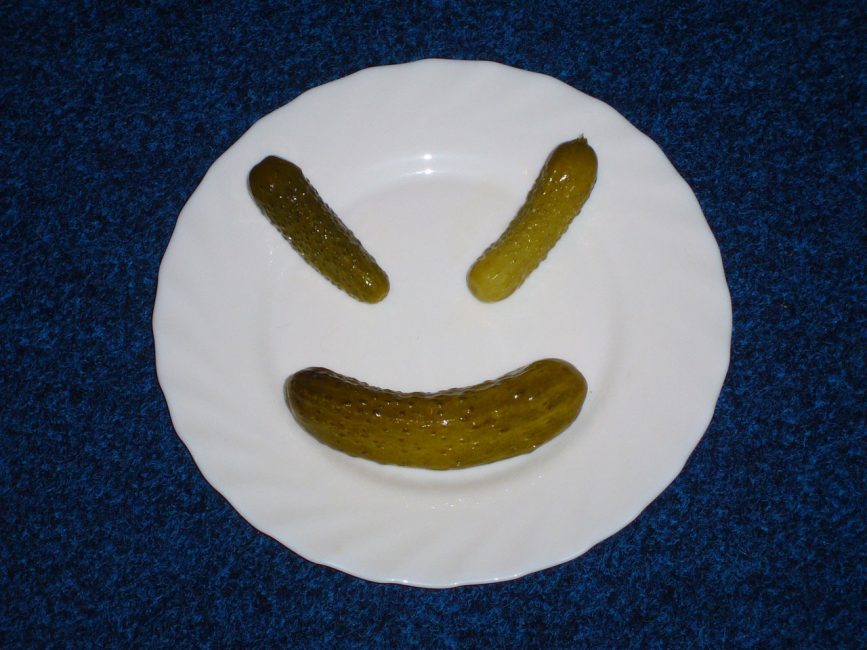 tre gurkor på en tallrik i form av en smiley