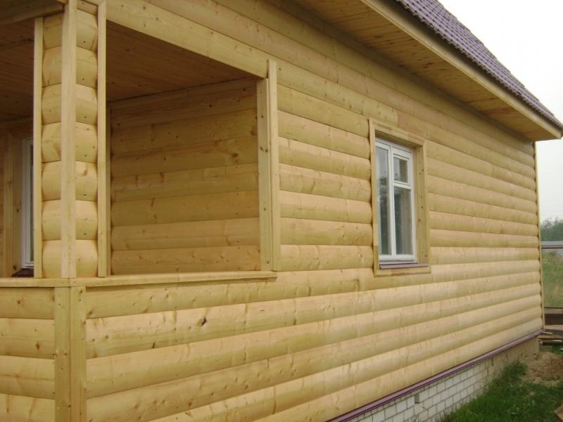 Fasaddekoration under en träram. Blockhus används
