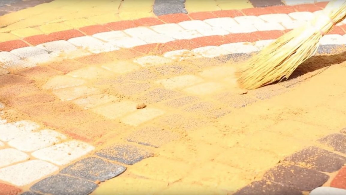 Dále je písek rovnoměrně rozložen po povrchu pomocí běžného koštěte.