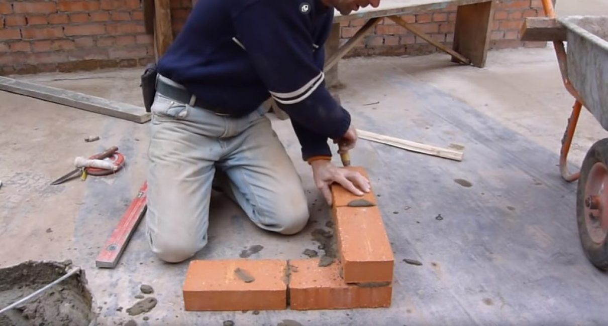 Úder zednickou lžící na konec cihlové zdi vytlačí rohovou cihlu