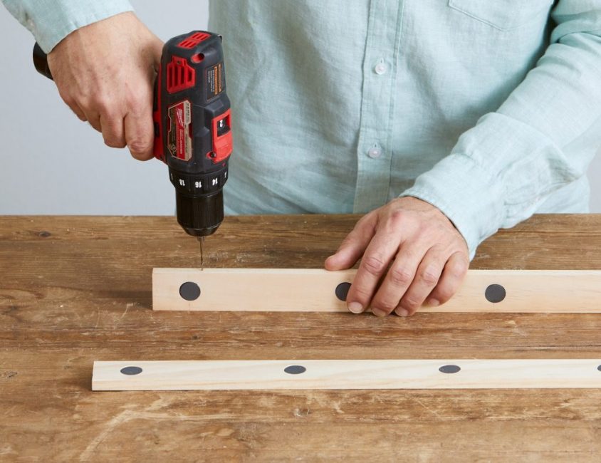 Una tabla se gira con el lado del extremo y se hace un agujero para la cuerda con un pequeño taladro.