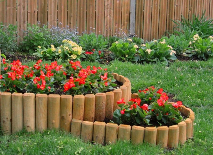 Macizos de flores de valla de madera de troncos semicirculares