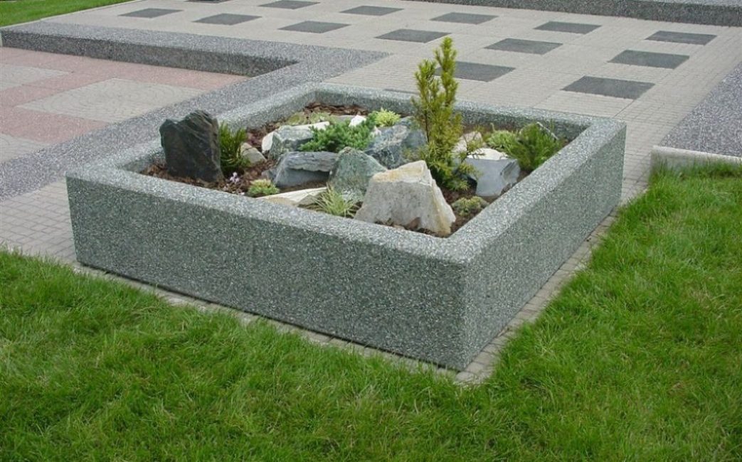 Macizo de flores con valla de hormigón