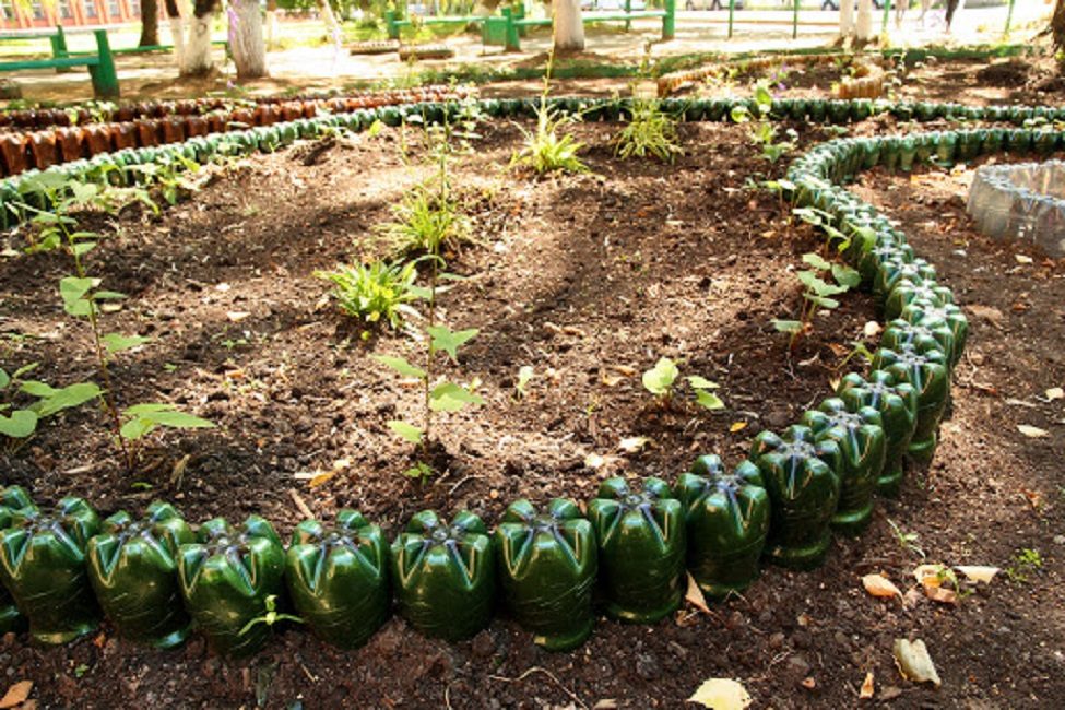 Esgrima macizos de flores hechos de botellas de plástico.